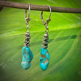 Turquoise & Thai Silver Dangle Earrings with leaf background